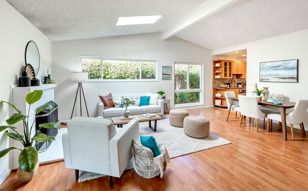 Mid-sized mid-century modern open concept medium tone wood floor, brown floor and vaulted ceiling living room photo in San Diego with a music area, white walls, a standard fireplace and a brick fireplace