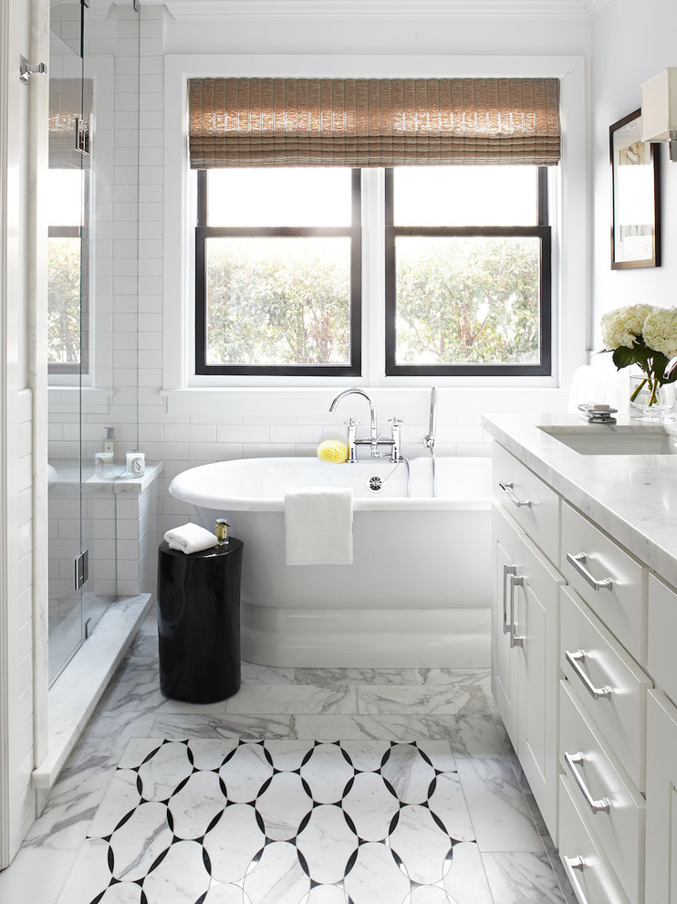 This is an example of a large traditional master bathroom in San Francisco with an undermount sink, white cabinets, marble benchtops, a freestanding tub, white tile, white walls, marble floors and flat-panel cabinets.