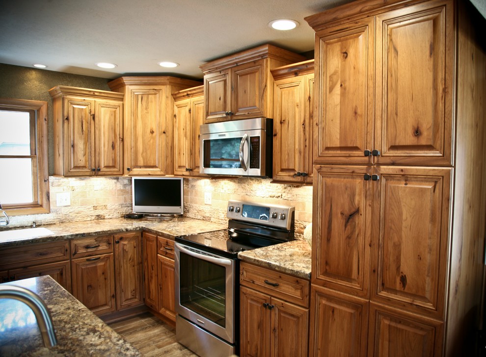 Inspiration for a mid-sized country l-shaped kitchen in Other with an undermount sink, raised-panel cabinets, medium wood cabinets, granite benchtops, stone tile splashback, stainless steel appliances, dark hardwood floors and with island.
