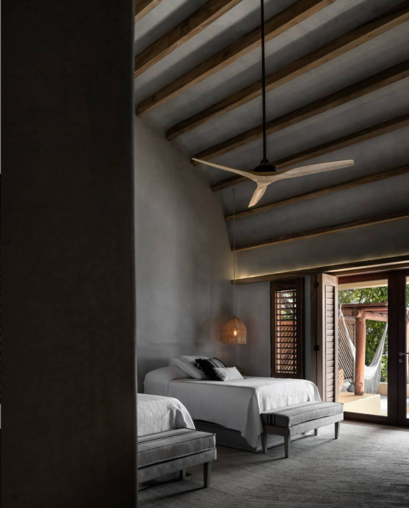На фото: большая хозяйская спальня в средиземноморском стиле с серыми стенами, полом из известняка, бежевым полом и балками на потолке