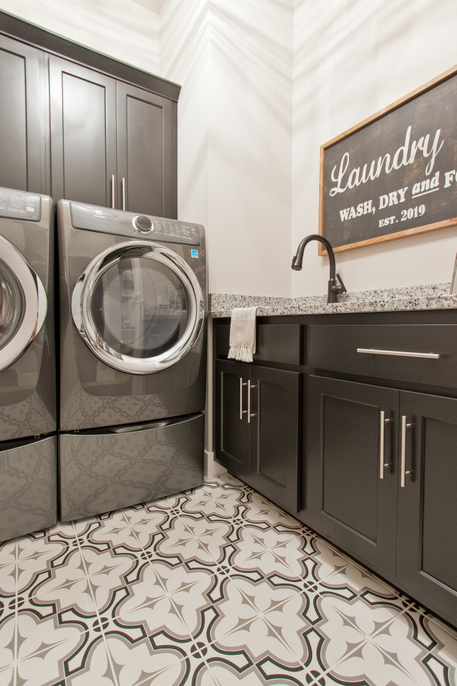 Inspiration for a mediterranean l-shaped laundry room with brown cabinets, quartz benchtops, porcelain floors, a side-by-side washer and dryer, multi-coloured floor and multi-coloured benchtop.