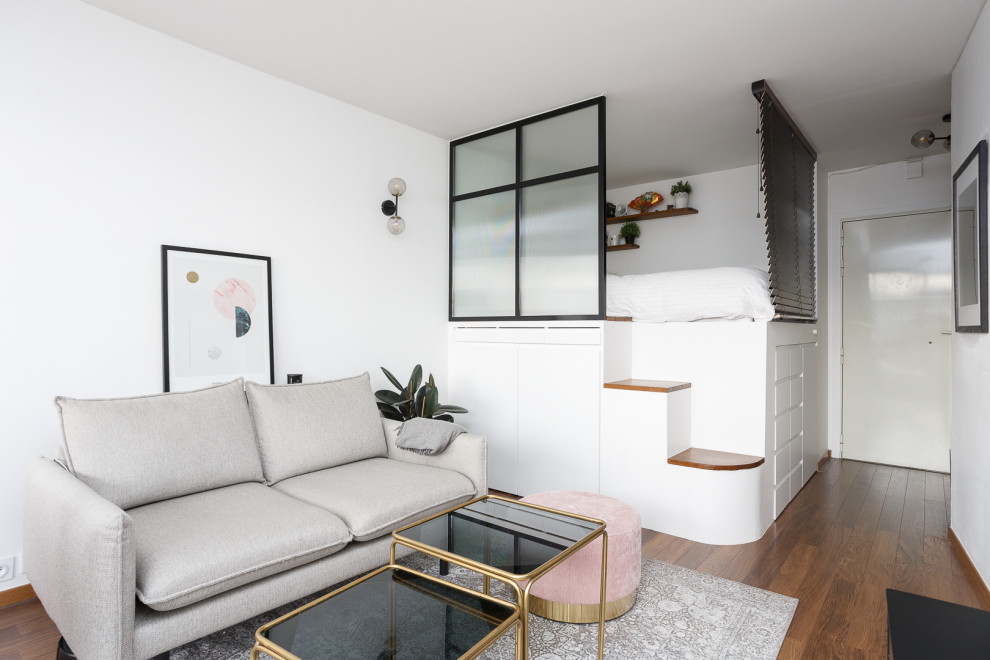Cette image montre une petite salle de séjour ouverte avec un mur blanc, parquet foncé, aucune cheminée, un téléviseur indépendant et un sol marron.