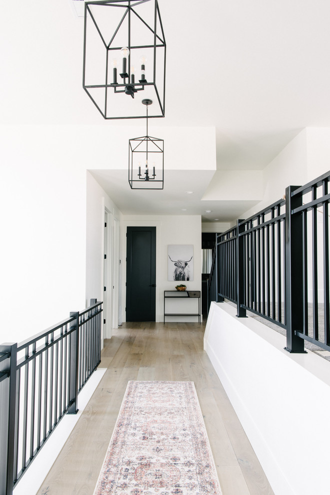 Inspiration for a mid-sized contemporary hallway in Salt Lake City with white walls, light hardwood floors and beige floor.