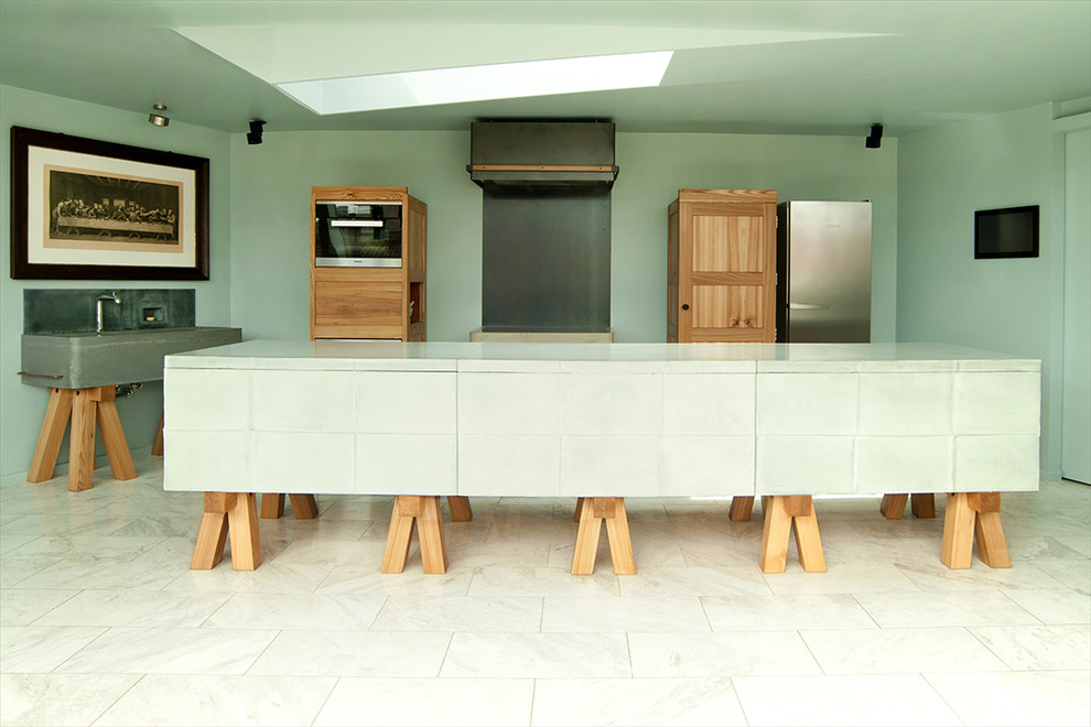 This is an example of a large contemporary open plan kitchen in Berlin with a single-bowl sink, medium wood cabinets, concrete benchtops, multi-coloured splashback, stainless steel appliances, marble floors and with island.