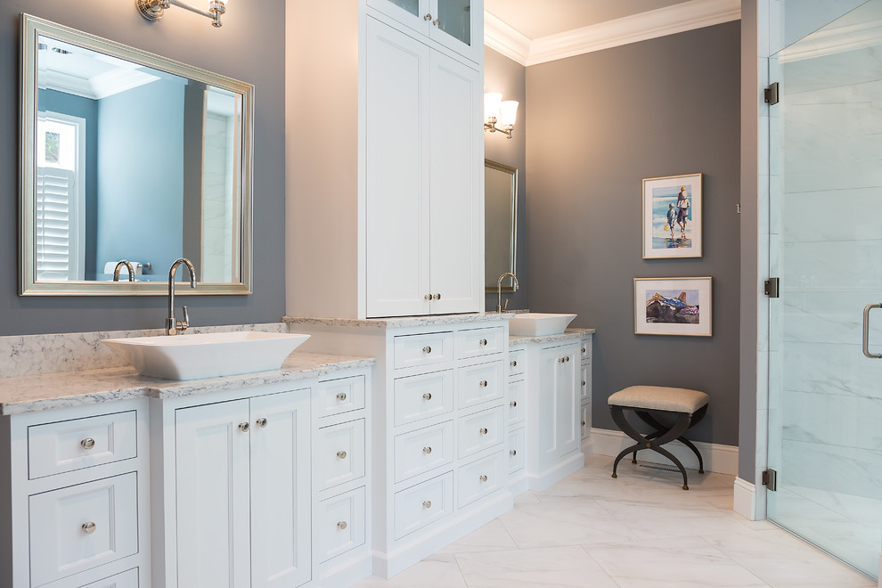 Large transitional master gray tile and stone tile marble floor and white floor freestanding bathtub photo with recessed-panel cabinets, white cabinets, gray walls, a vessel sink, marble countertops and a hinged shower door