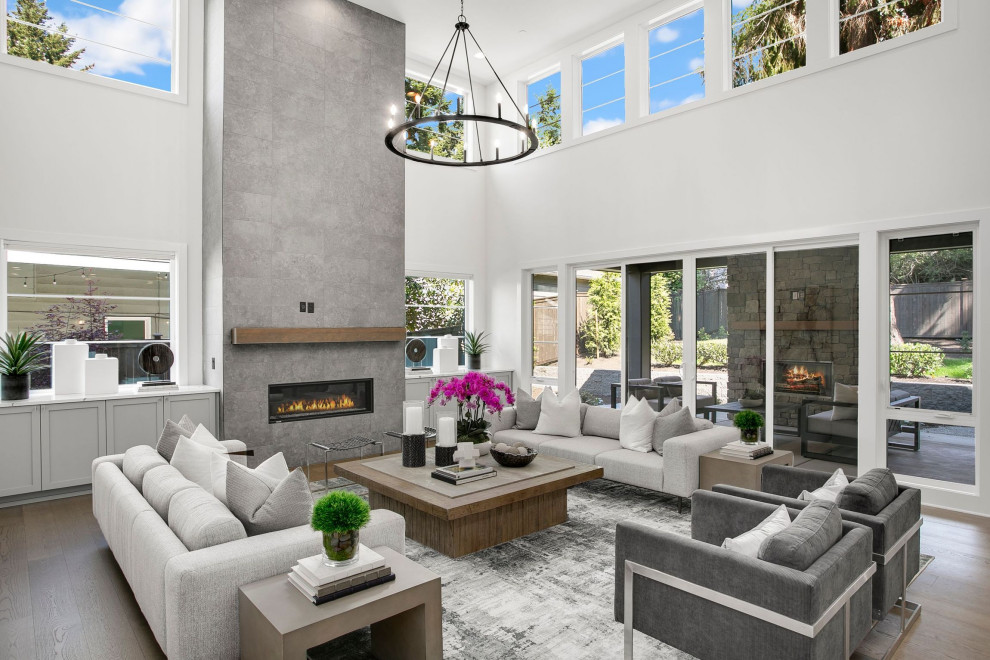 Large contemporary open concept living room in Seattle with white walls, dark hardwood floors, a standard fireplace, a stone fireplace surround, brown floor and vaulted.