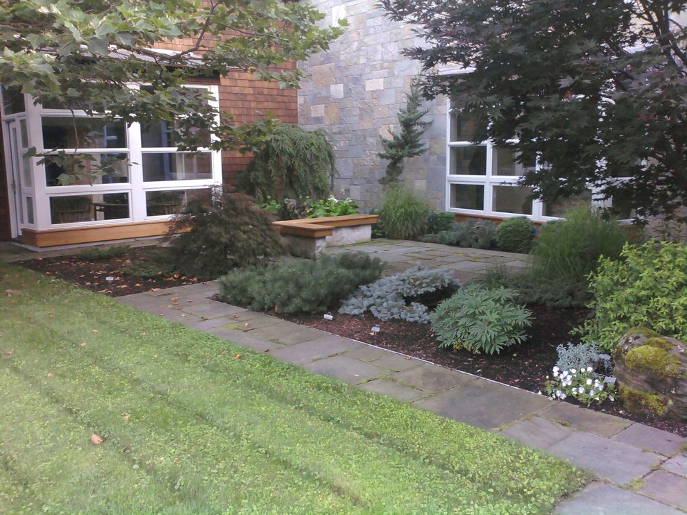 This is an example of a large contemporary front yard garden in Burlington with natural stone pavers.