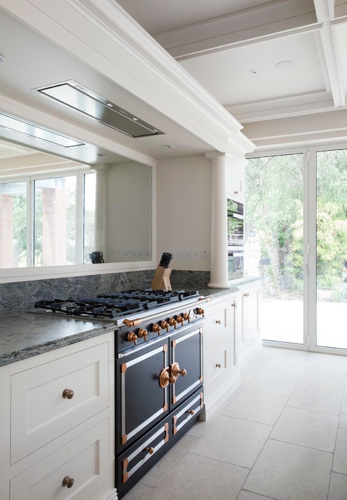 Large transitional single-wall eat-in kitchen in Dublin with a drop-in sink, shaker cabinets, white cabinets, quartzite benchtops, mirror splashback, black appliances, ceramic floors, with island, grey floor and green benchtop.
