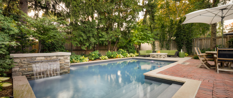 Photo of a traditional backyard pool in Toronto with a pool house.
