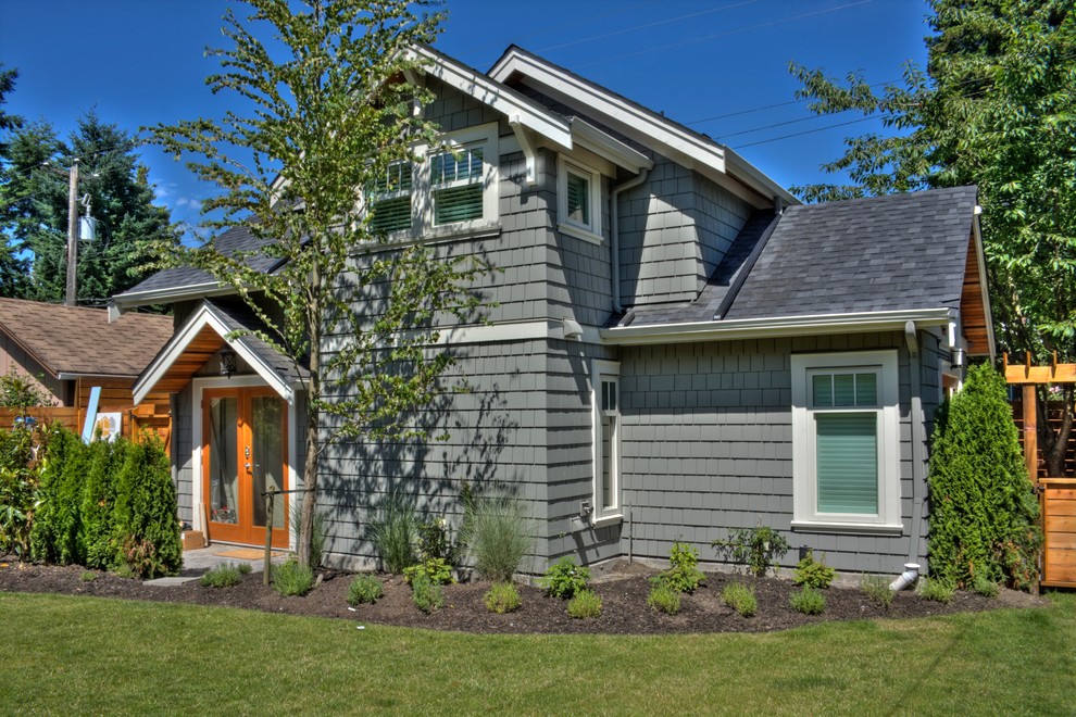 Design ideas for a traditional two-storey grey exterior in Vancouver with wood siding.