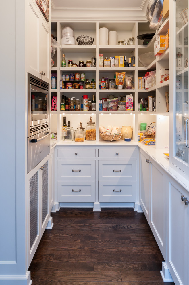 Inspiration for a traditional kitchen pantry in Seattle with recessed-panel cabinets, white cabinets, stainless steel appliances and dark hardwood floors.