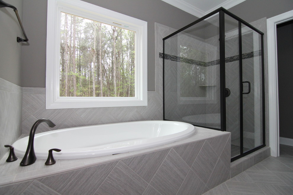 Photo of a medium sized ensuite bathroom in Raleigh with beaded cabinets, dark wood cabinets, a corner bath, a corner shower, grey tiles, ceramic tiles, grey walls, ceramic flooring, an integrated sink and solid surface worktops.