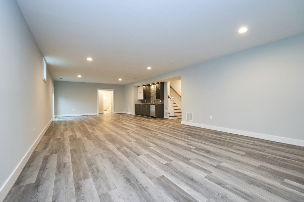 Large transitional walk-out vinyl floor and gray floor basement photo in DC Metro with gray walls