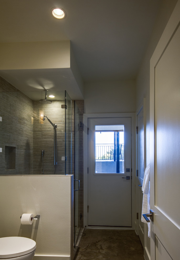 This is an example of a mid-sized contemporary 3/4 bathroom in Austin with an integrated sink, flat-panel cabinets, white cabinets, a corner shower, a one-piece toilet, gray tile and white walls.