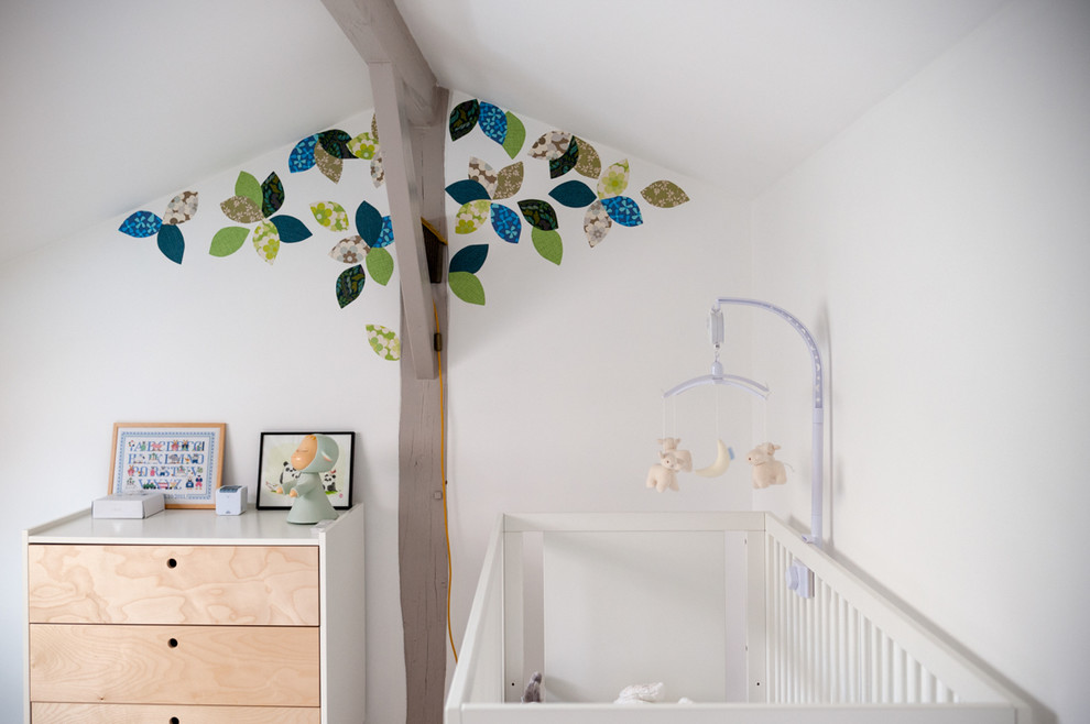 Cette photo montre une chambre de bébé neutre tendance de taille moyenne avec un mur blanc.