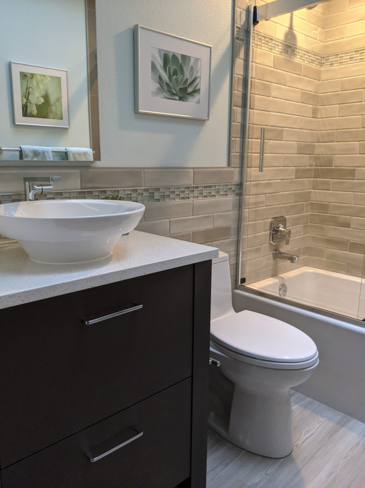 Photo of a small transitional kids bathroom in Seattle with furniture-like cabinets, brown cabinets, a drop-in tub, a shower/bathtub combo, a one-piece toilet, brown tile, mosaic tile, green walls, porcelain floors, a vessel sink, engineered quartz benchtops, brown floor, a sliding shower screen and white benchtops.