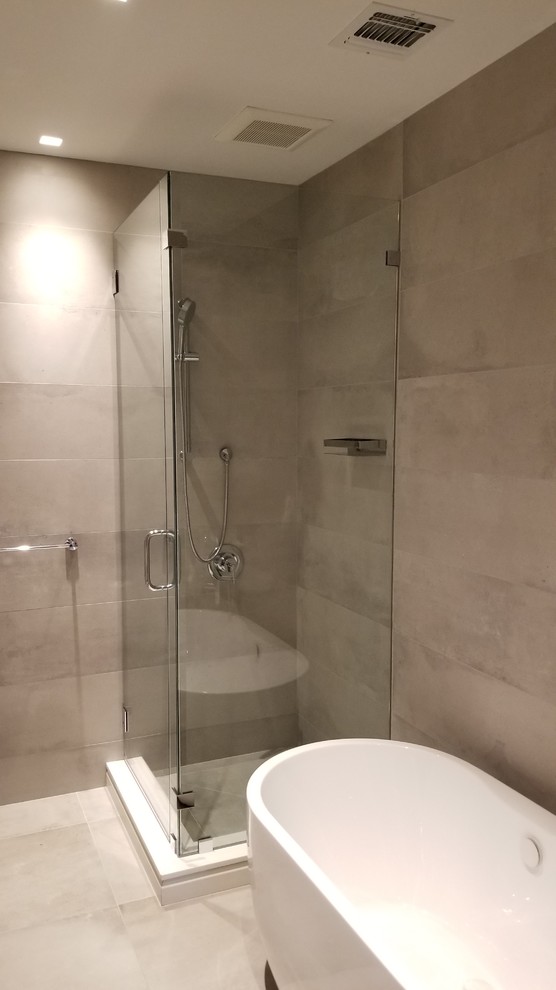 This is an example of a mid-sized modern master bathroom in New York with a corner shower and a hinged shower door.