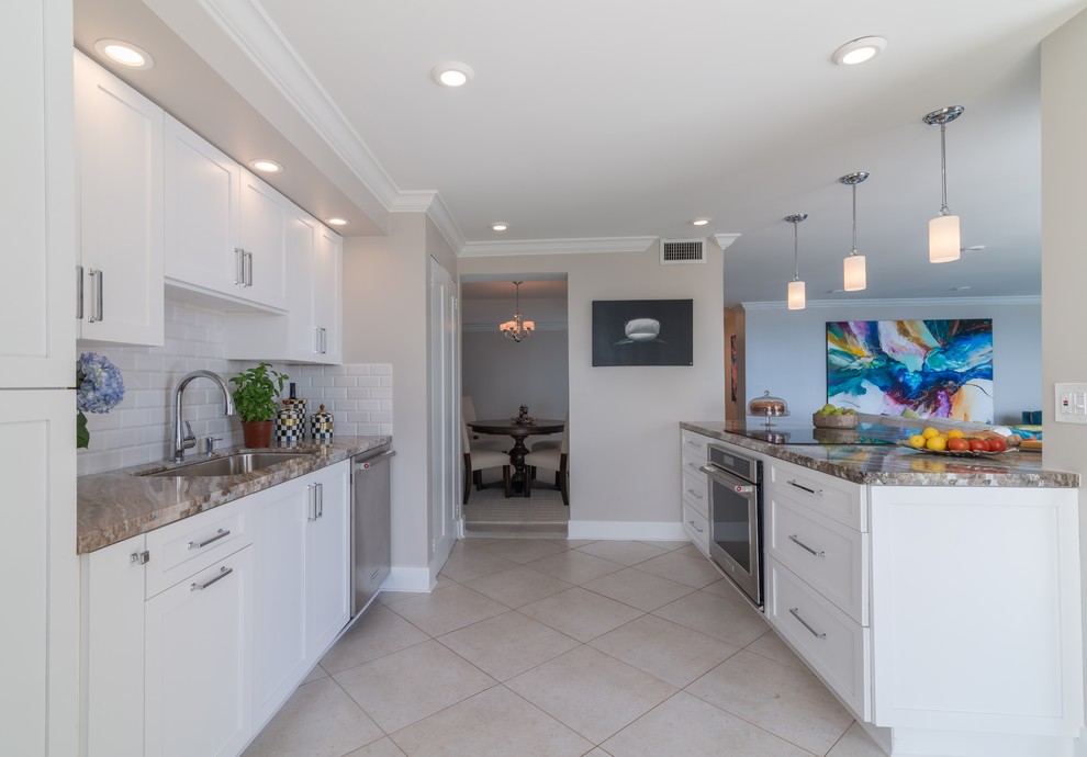Mid-sized transitional galley porcelain tile eat-in kitchen photo in Miami with an undermount sink, shaker cabinets, white cabinets, granite countertops, white backsplash, subway tile backsplash, stainless steel appliances and a peninsula