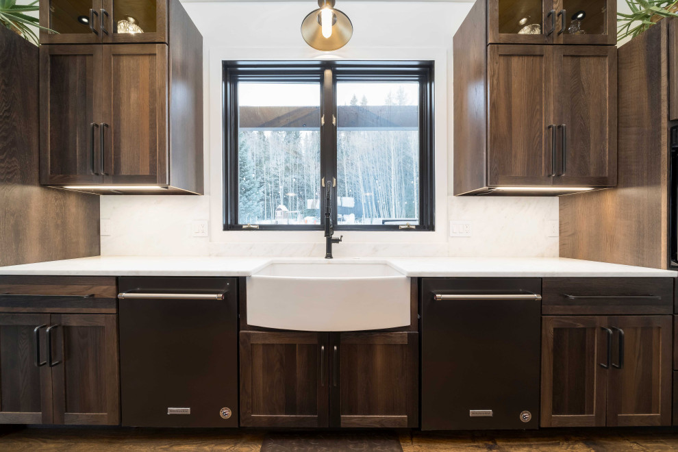 Photo of an expansive transitional single-wall open plan kitchen in Denver with a farmhouse sink, shaker cabinets, dark wood cabinets, marble benchtops, panelled appliances, dark hardwood floors, with island, brown floor, white benchtop and timber.