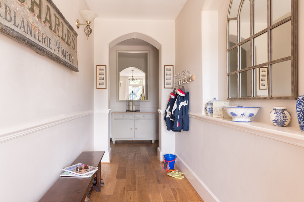 Large country entry hall in Devon with beige walls and medium hardwood floors.