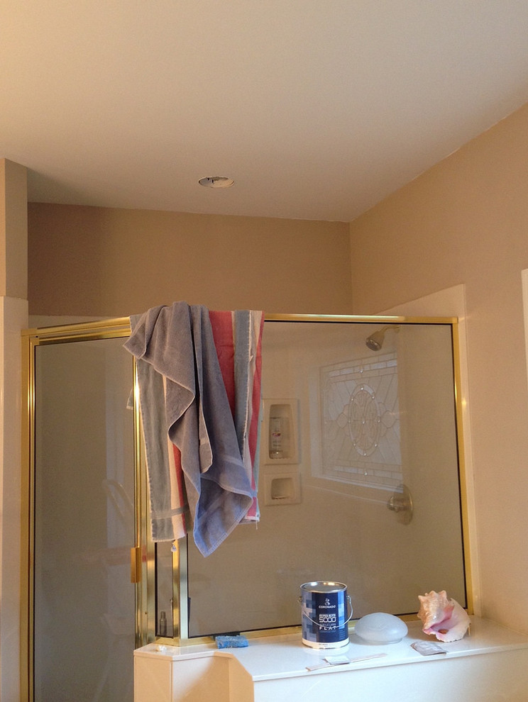 Inspiration for a large transitional master beige tile and ceramic tile ceramic tile and beige floor drop-in bathtub remodel with raised-panel cabinets, dark wood cabinets, a two-piece toilet, beige walls, an undermount sink, quartzite countertops, a hinged shower door and brown countertops