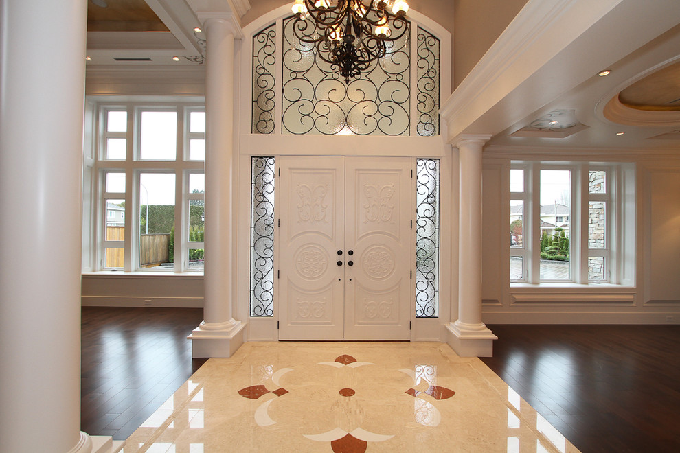 Example of a large transitional marble floor foyer design in Vancouver with a white front door