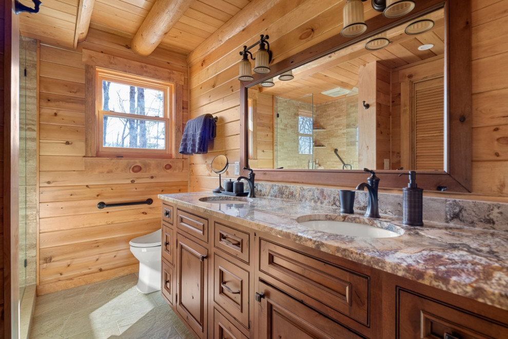 This is an example of a mid-sized country 3/4 bathroom in Other with beaded inset cabinets, medium wood cabinets, a one-piece toilet, a drop-in sink, granite benchtops, grey floor, a hinged shower door, beige benchtops, a double vanity, a built-in vanity and wood.
