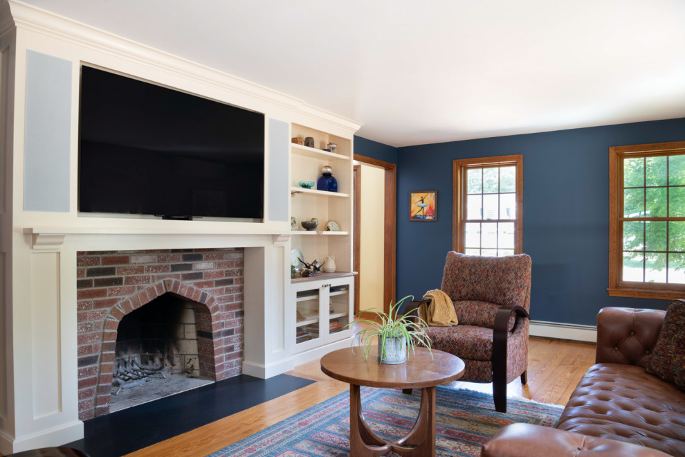 Foto på ett mellanstort vintage separat vardagsrum, med blå väggar, mellanmörkt trägolv, en standard öppen spis, en spiselkrans i tegelsten, en väggmonterad TV och brunt golv