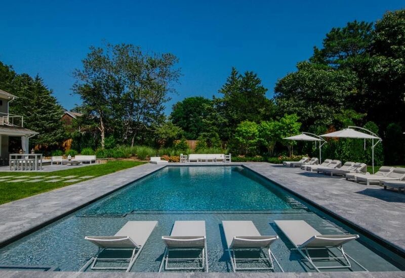 Example of a large backyard stone and rectangular lap pool design in New York