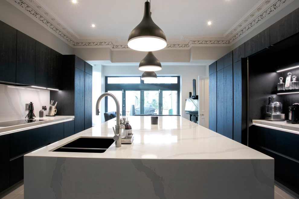 Large contemporary kitchen/diner in Other with a submerged sink, flat-panel cabinets, composite countertops, black appliances, an island and white worktops.
