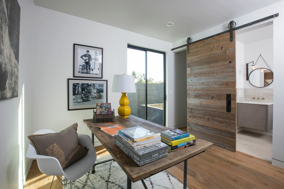 Contemporary home office in Los Angeles with white walls, medium hardwood floors and a freestanding desk.