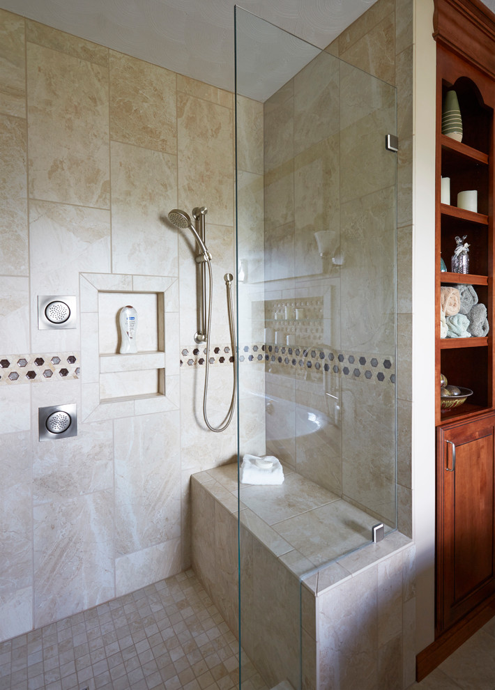 Photo of a large mediterranean master bathroom in Seattle with furniture-like cabinets, medium wood cabinets, a freestanding tub, an alcove shower, a two-piece toilet, beige tile, porcelain tile, beige walls, porcelain floors, a vessel sink, solid surface benchtops and beige floor.