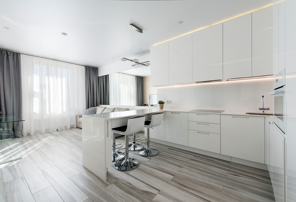 Design ideas for a mid-sized modern u-shaped open plan kitchen in Palma de Mallorca with flat-panel cabinets, white cabinets, white splashback, white appliances and a peninsula.
