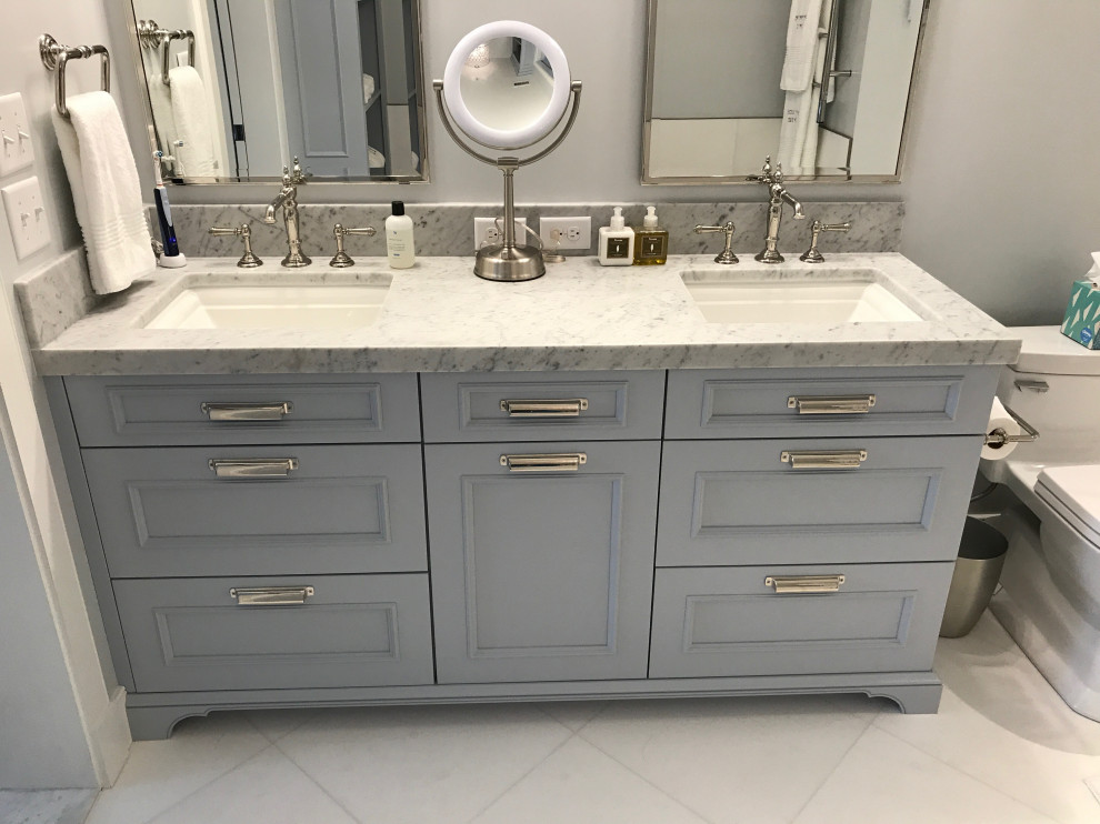 Inspiration for a transitional bathroom in Baltimore with flat-panel cabinets, blue cabinets, a freestanding tub, an alcove shower, a one-piece toilet, white tile, marble, blue walls, marble floors, an undermount sink, marble benchtops, white floor, a hinged shower door, a shower seat and a double vanity.