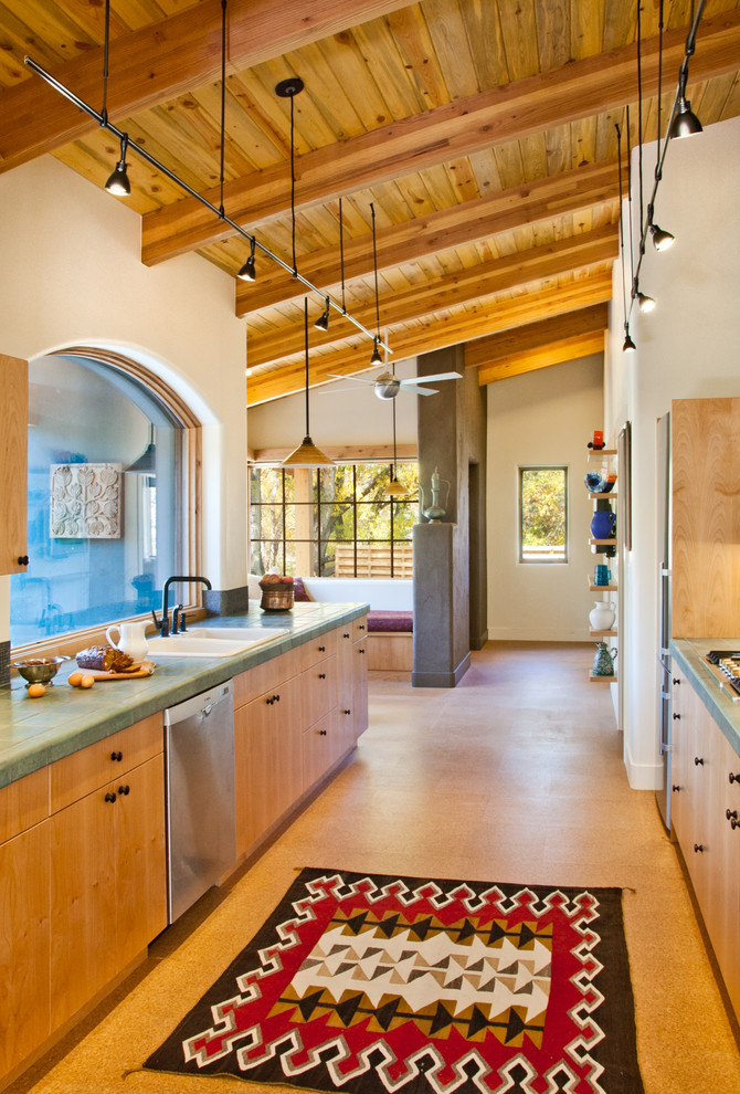 Photo of a galley kitchen in Denver with a drop-in sink, flat-panel cabinets, light wood cabinets and green benchtop.