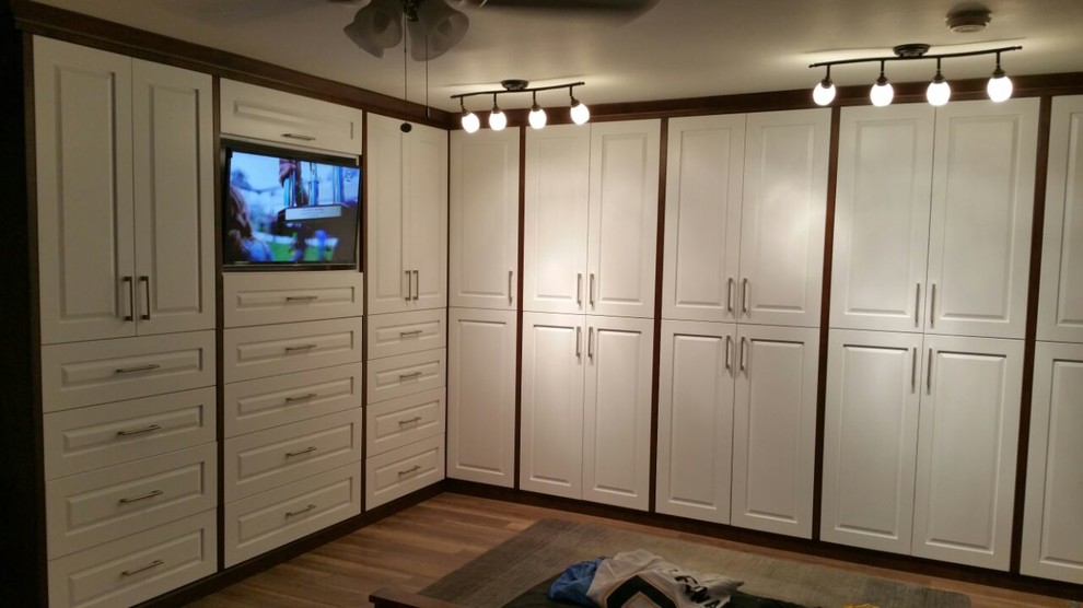 Inspiration for a mid-sized contemporary gender-neutral walk-in wardrobe in San Diego with raised-panel cabinets, white cabinets and light hardwood floors.