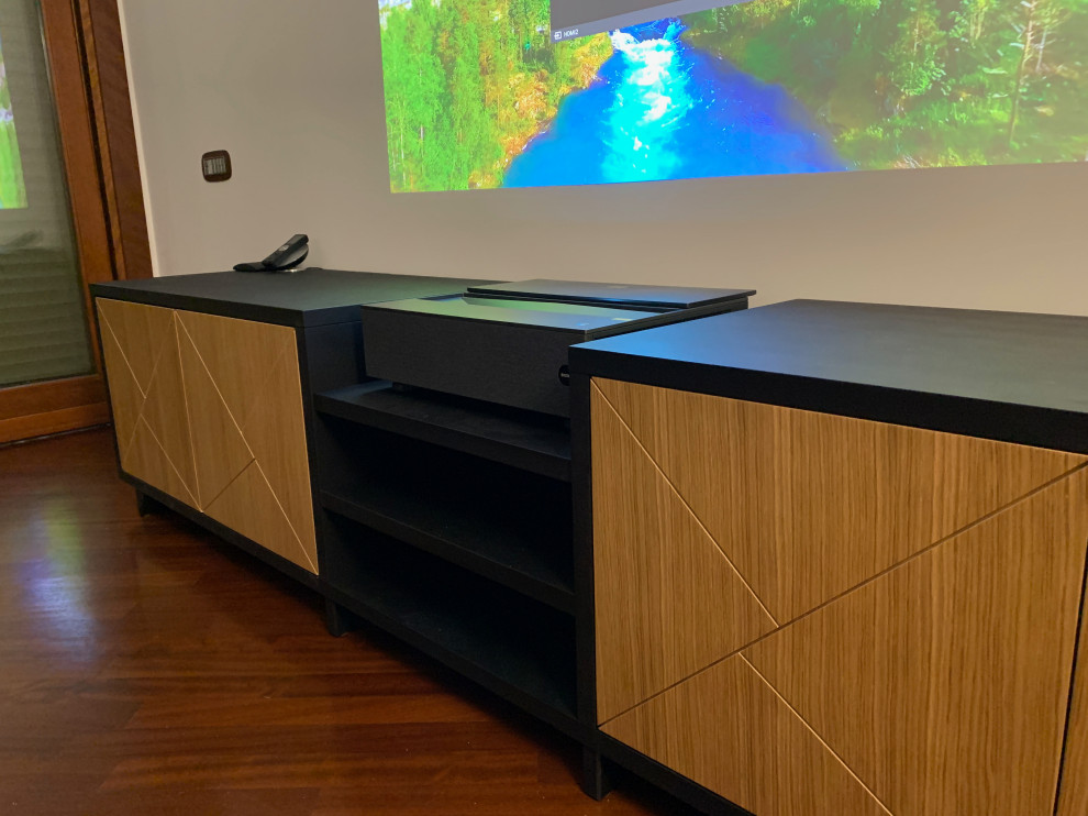 This is an example of a mid-sized industrial enclosed home theatre in Rome with white walls, dark hardwood floors and brown floor.