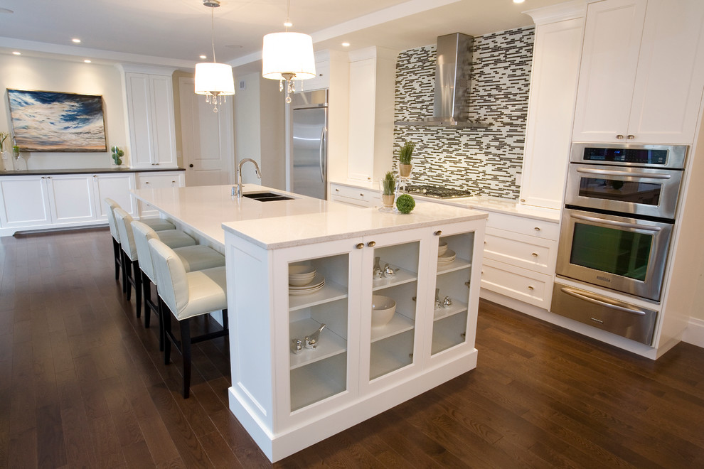 Large transitional medium tone wood floor eat-in kitchen photo in Calgary with an undermount sink, recessed-panel cabinets, white cabinets, quartz countertops, multicolored backsplash, mosaic tile backsplash, stainless steel appliances and an island