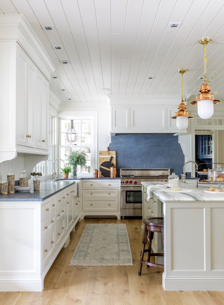 Inspiration for a classic kitchen in Minneapolis with stainless steel appliances, light hardwood flooring, an island and a timber clad ceiling.