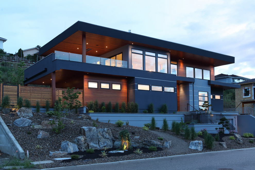 This is an example of a large contemporary two-storey multi-coloured house exterior in Vancouver with mixed siding and a flat roof.