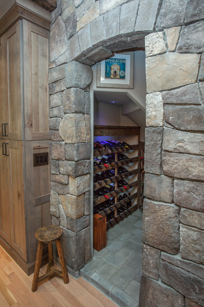 Photo of a mid-sized country wine cellar in Portland with concrete floors, storage racks and grey floor.