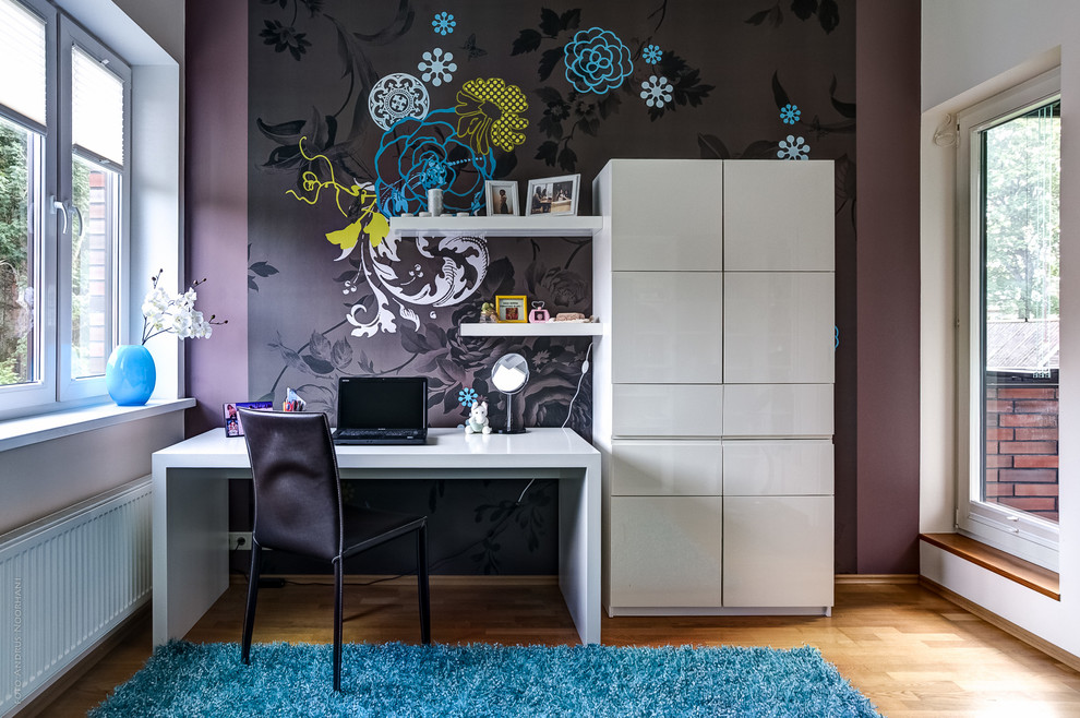 This is an example of a contemporary kids' room for girls in Other with purple walls and light hardwood floors.