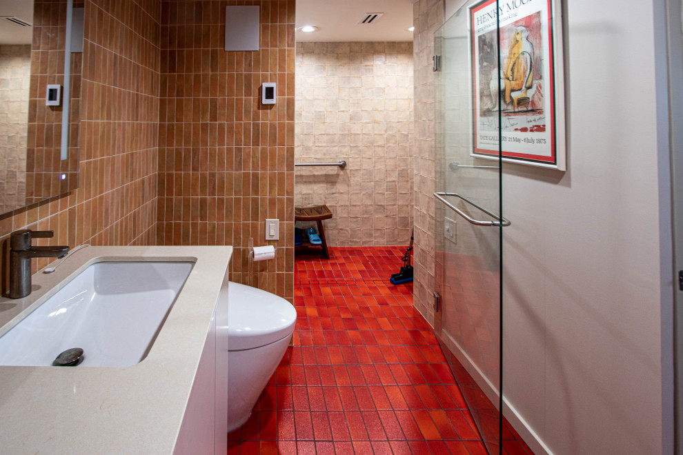 Cette image montre une salle de bain principale vintage de taille moyenne avec un placard à porte plane, des portes de placard beiges, une baignoire en alcôve, une douche à l'italienne, WC à poser, un carrelage marron, des carreaux de céramique, un mur beige, un sol en carrelage de céramique, un lavabo encastré, un plan de toilette en quartz modifié, un sol rouge, une cabine de douche à porte battante, un plan de toilette beige, une niche, meuble simple vasque et meuble-lavabo encastré.