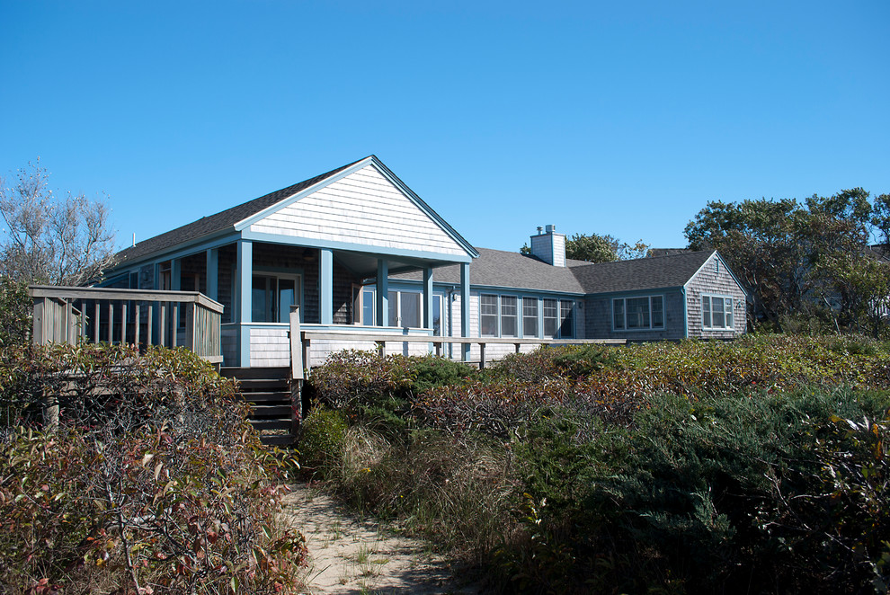 This is an example of a beach style one-storey exterior in Boston with wood siding.