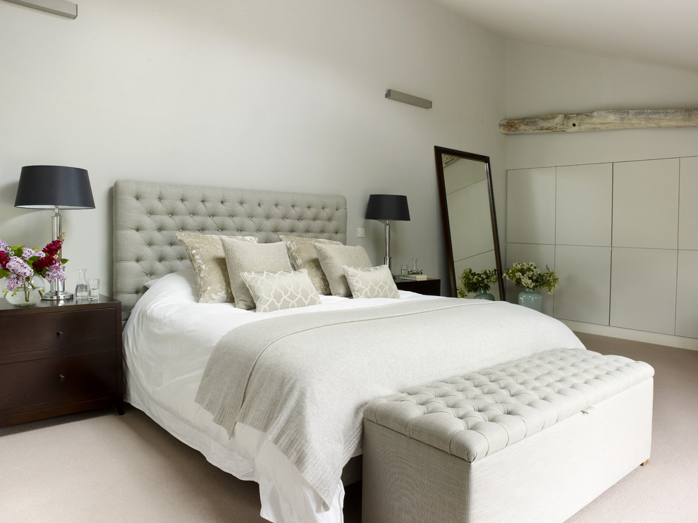 This is an example of a mid-sized country master bedroom in London with grey walls and carpet.