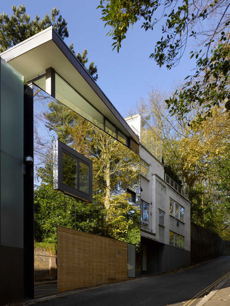 This is an example of a contemporary three-storey glass exterior in London with a shed roof.