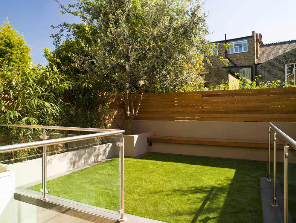 Photo of a small modern backyard partial sun formal garden for summer in London with a garden path and decking.
