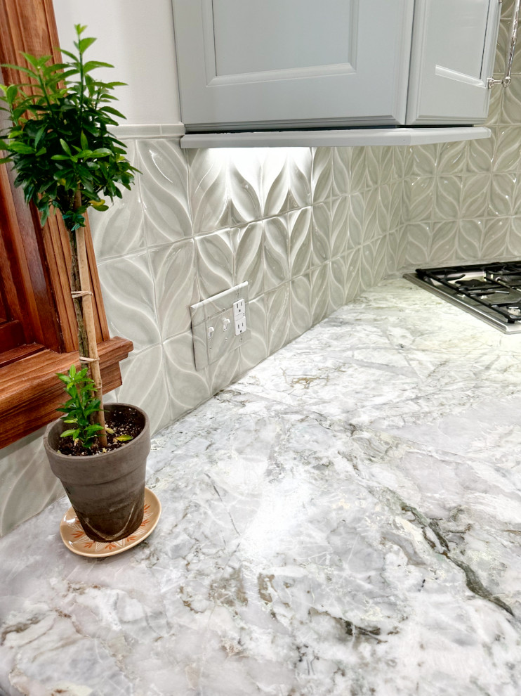 Transitional l-shaped medium tone wood floor eat-in kitchen photo with shaker cabinets, green cabinets, quartzite countertops, porcelain backsplash, paneled appliances and an island