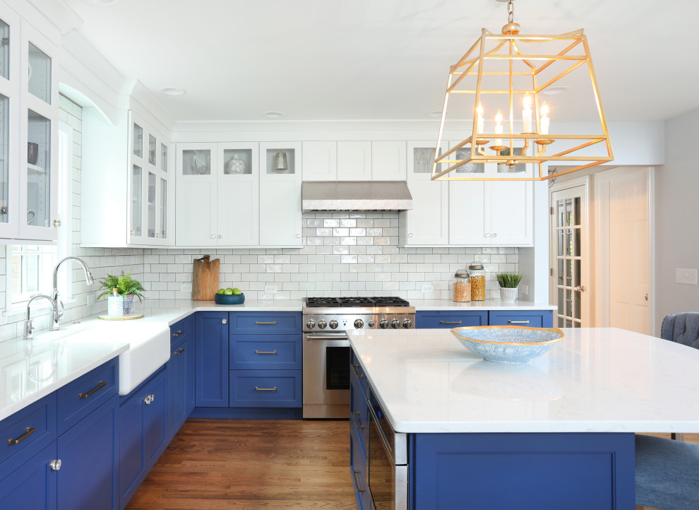 Eat-in kitchen - large transitional l-shaped medium tone wood floor and brown floor eat-in kitchen idea in Chicago with a farmhouse sink, beaded inset cabinets, quartz countertops, white backsplash, glass tile backsplash, paneled appliances, an island, white countertops and white cabinets