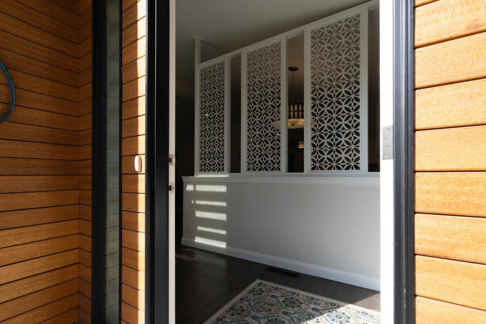 This is an example of a mid-sized midcentury front door in Calgary with dark hardwood floors and brown floor.